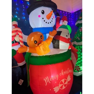 bonhomme de neige gonflable dans une tasse avec un pingouin et un biscuit en pain d'épice